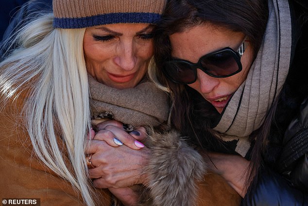 People mourn at a makeshift memorial outside the "Le Constellation" bar, after a deadly fire and explosion during a New Year's Eve party in the upscale ski resort of Crans-Montana in southwestern Switzerland, January 4, 2026