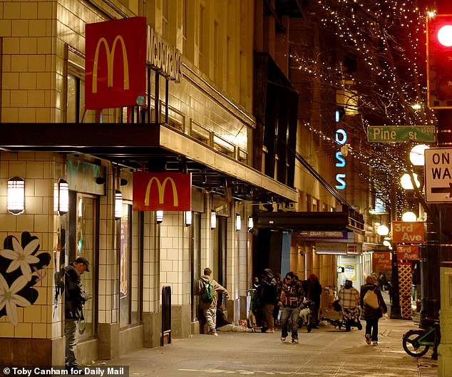 A group of vagrants can be seen congregating outside the McDonald's last week. Anyone wishing to order a food must run a gauntlet of chaos and despair