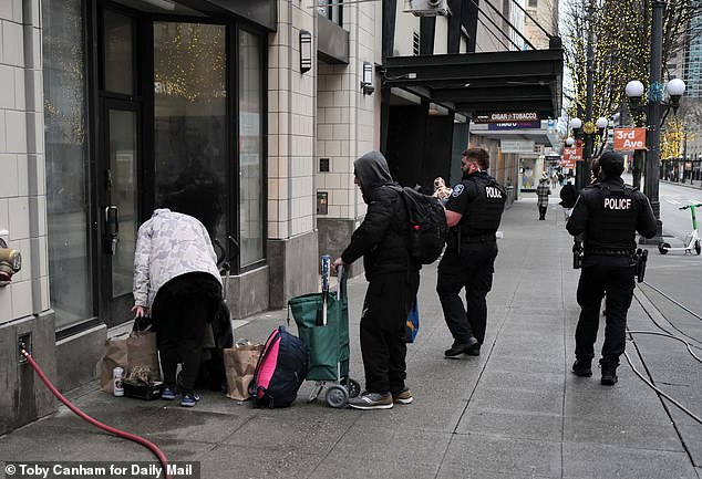 Two policemen urged people hanging out on the street to move because the city was going to 'spray' the area