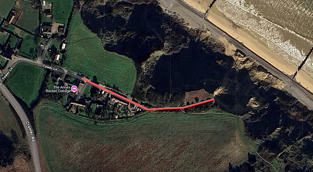 The byway runs past a small row of houses before angling left and heading through dense foliage before meeting the crumbling coastline