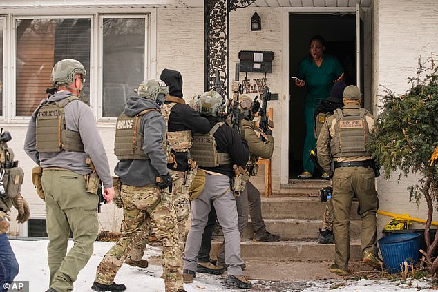 A family member reacts after a federal immigration officer used a battering ram to break down a door before making an arrest Sunday