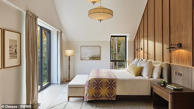 Upstairs, the luxurious main bedroom features a freestanding bath overlooking the lake and forest beyond, alongside an en suite bathroom and dressing area