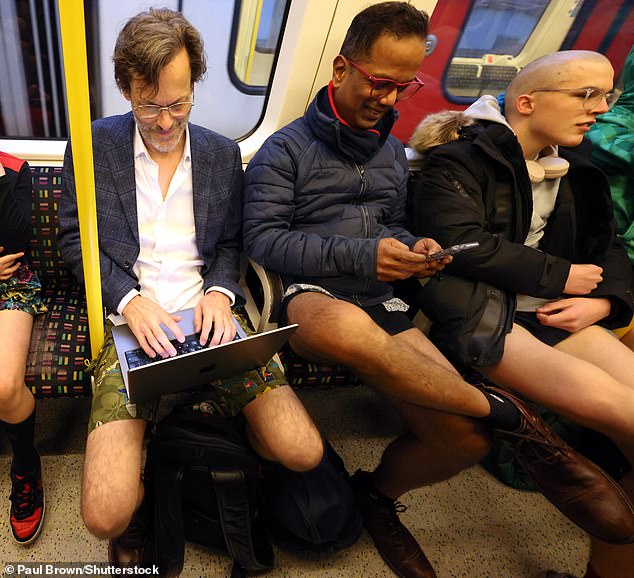 People sit on an Underground train during the annual No Trousers Tube Ride on Sunday