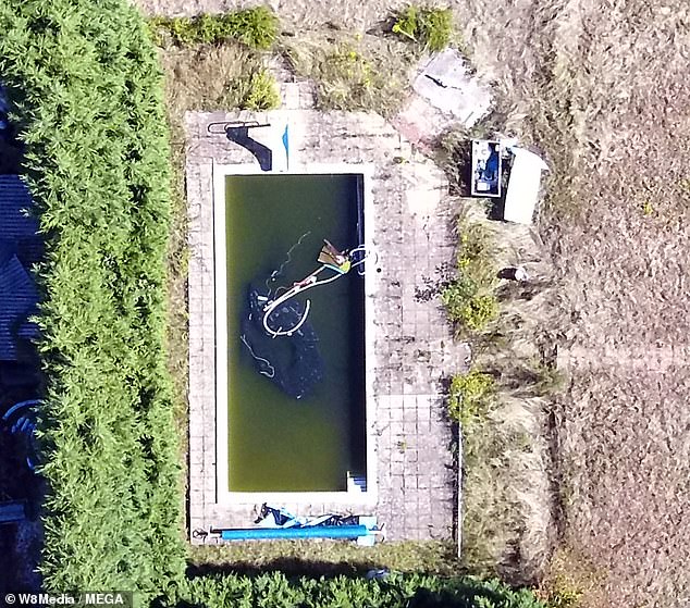 An aerial view of the swimming pool filled with grimy water - pictured in August 2018
