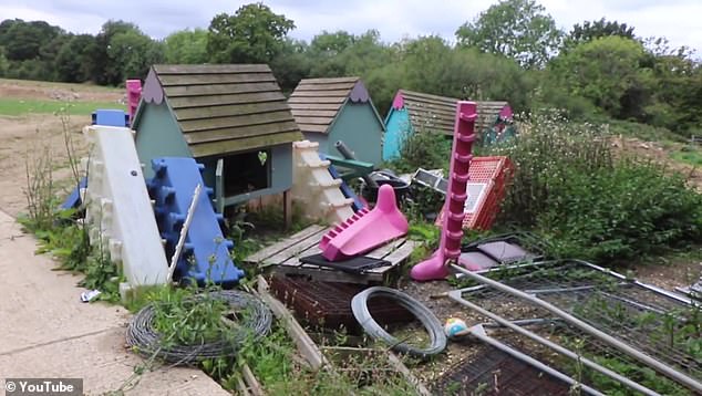 Some discarded children's play equipment sits among cables and metal fences in the garden during Katie's renovation project