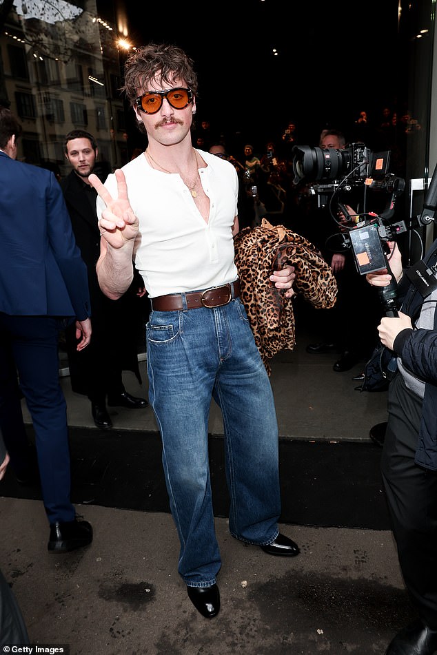 The musician stuck up a peace sign as he entered the runway