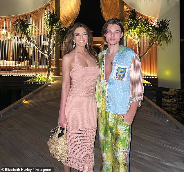 She walked around the exclusive destination in a nude bodycon dress as she posed up a storm with her model son, Damien, who she shares with ex Steve Bing
