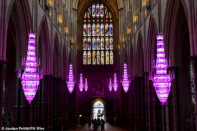 Westminster Abbey's glass chandeliers are lit in purple to mark Holocaust Memorial Day in 2025