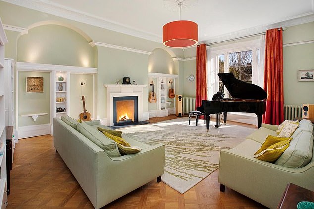 Pictures inside the house show an enormous living room with a grand piano, high ceilings and a log fire