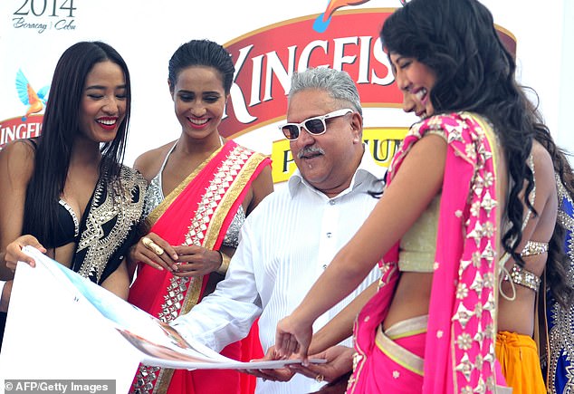 Mallya in December 2023, posing with models at a launch of the Kingfisher 2014 calendar in Mumbai, India