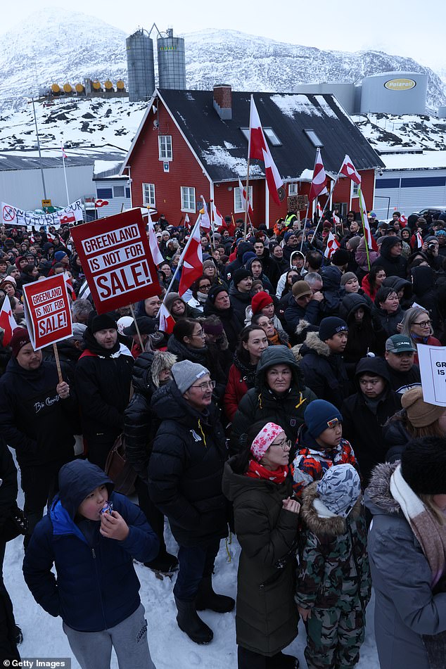 People bear Greenlandic flags and placards that read 'Greenland Is Not For Sale' as they gather in front of the US consulate to protest against President Donald Trump's plans for Greenland on January 17, 2026 in Nuuk, Greenland