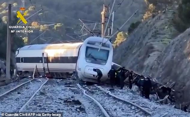 The crash occurred on Sunday evening when the tail end of a train carrying some 300 passengers on the route from Malaga to the capital, Madrid, went off the rails. It slammed into an incoming train travelling from Madrid to Huelva. Pictured: Emergency workers at the site of the track on Monday