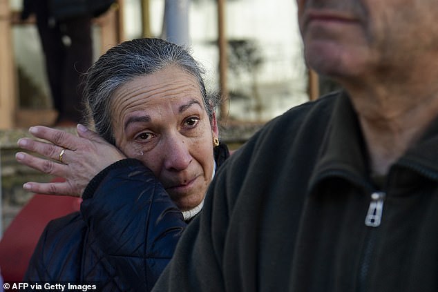 A woman wipes a tear from her cheek during a minute of silence for victims of a train accident in Adamuz, southern Spain, on January 19, 2026