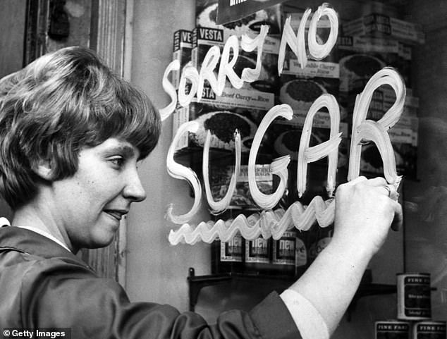 Food in the early 1970s was relatively expensive when considered as a proportion of household income. Pictured, a woman paints a 'Sorry No Sugar' sign on a shop window in Liverpool, 1974