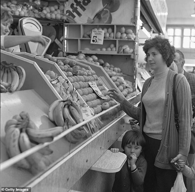Less than half of families owned a freezer, so ingredients had to be collected on a daily basis – often meaning housewives walking miles around the shops. Pictured, a mother and daughter buying fresh fruit from a greengrocers stall in Stafford's indoor market, circa 1974