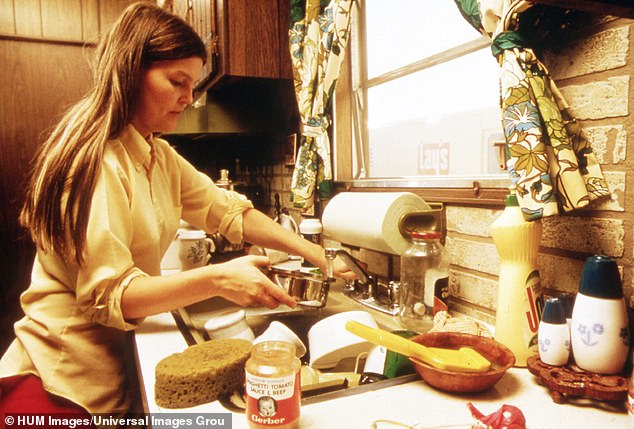 A typical family home-cooked meal included 'meat and two veg or maybe macaroni cheese', says food historian Pen Vogler. Pictured, a housewife in the 1970s preparing to fix a meal
