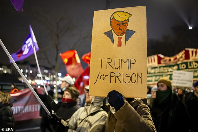People carried anti-Trump signs with the slogans 'Trump not welcome, 'Trump for prison,' and 'Trump is a criminal' amongst others