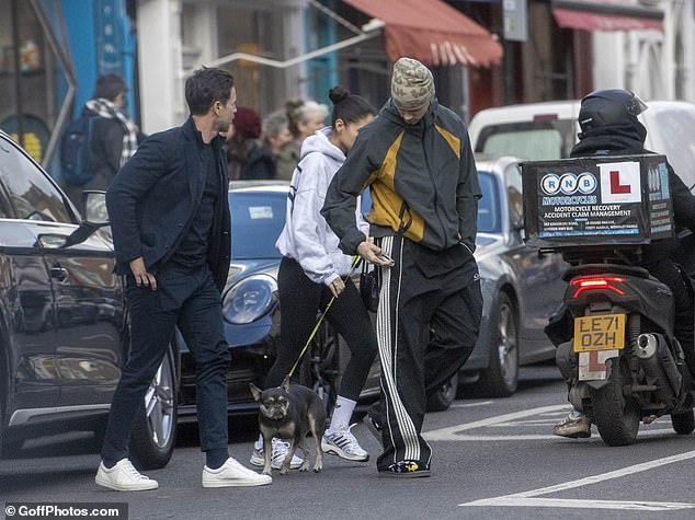 She finished her look with white gym socks, chunky white and silver trainers, and toted her belongings in a mini Chanel tote bag, which retails from £1,800
