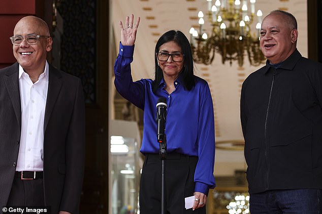 Venezuela's interim president Delcy Rodri­guez waves next to National Assembly president Jorge Rodri­guez (left) and Minister of Interior Diosdado Cabello during a press conference regarding the release of prisoners in Venezuela at Miraflores Palace on January 14