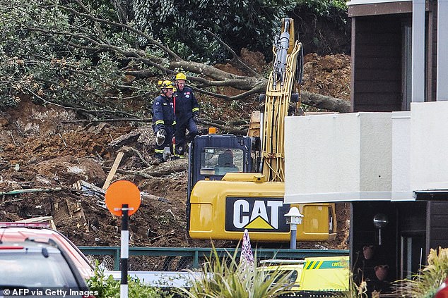 Police and officials stand following a landslide while a search is underway by local emergency services for missing people at Mount Maunganui in Tauranga on January 22, 2026