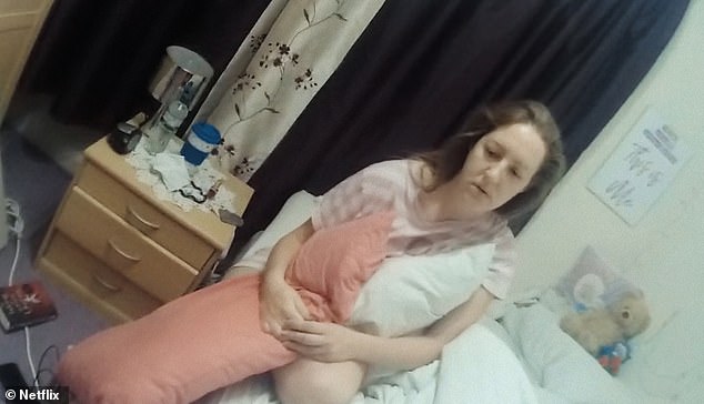Lucy Letby sits up in her bed as she is arrested by police in the never-before-seen footage