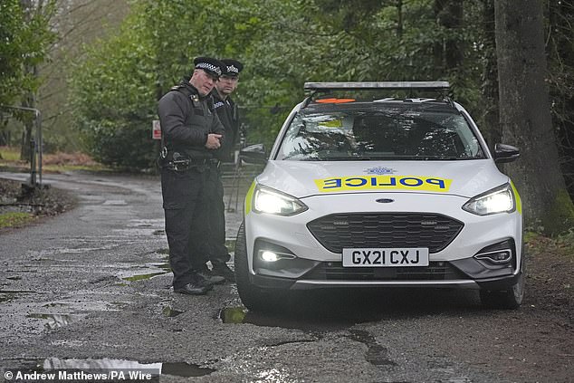 Police officers outside the former military base this afternoon after the arrival of illegal migrants