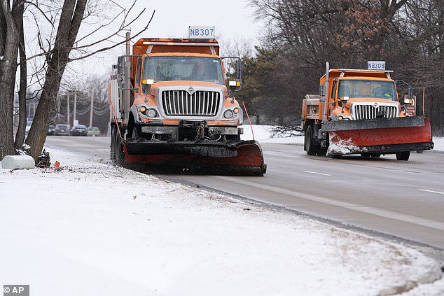 Governors in several states have declared a state of emergency to deploy resources ahead of the storm. Snow plows are pictured driving through a street in Northbrook, Illinois on Thursday