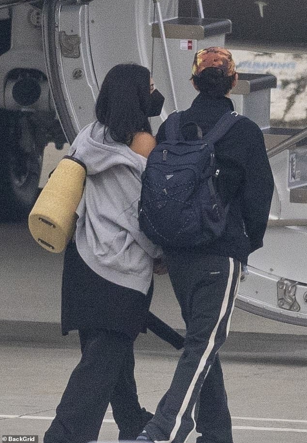 For their flight, Chalamet dressed casually in dark track pants, sneakers and a backpack, while Jenner opted for black leggings and a light gray hoodie, carrying a large beige tote bag