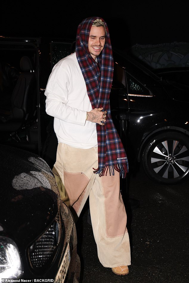 The former footballer opted for a smart-casual look in a white long-sleeved shirt paired with beige jeans as he led the way into the venue