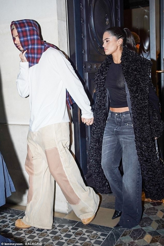 Flashing a glimpse of her taut midriff, Kim added inches to her frame with pointed black heels