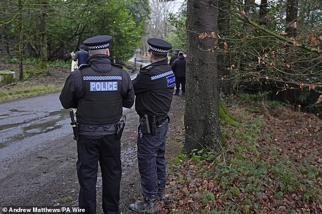 Police officers stand outside Crowborough Training Camp yesterday after the first group of migrants arrived