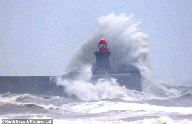 Waves crash against South Shields Lighthouse in South Tyneside this morning