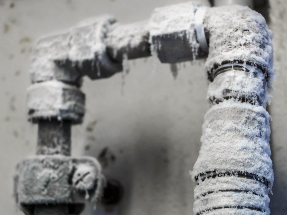 Frozen industrial pipes covered in ice.