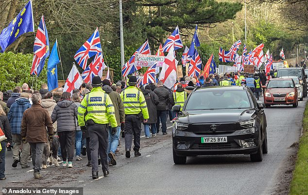 Hundreds of people waving flags and banners gather outside Crowborough Army Camp to protest the Home Office's plans to house 600 male migrants in a former army barracks in West Sussex, United Kingdom on January 18, 2026
