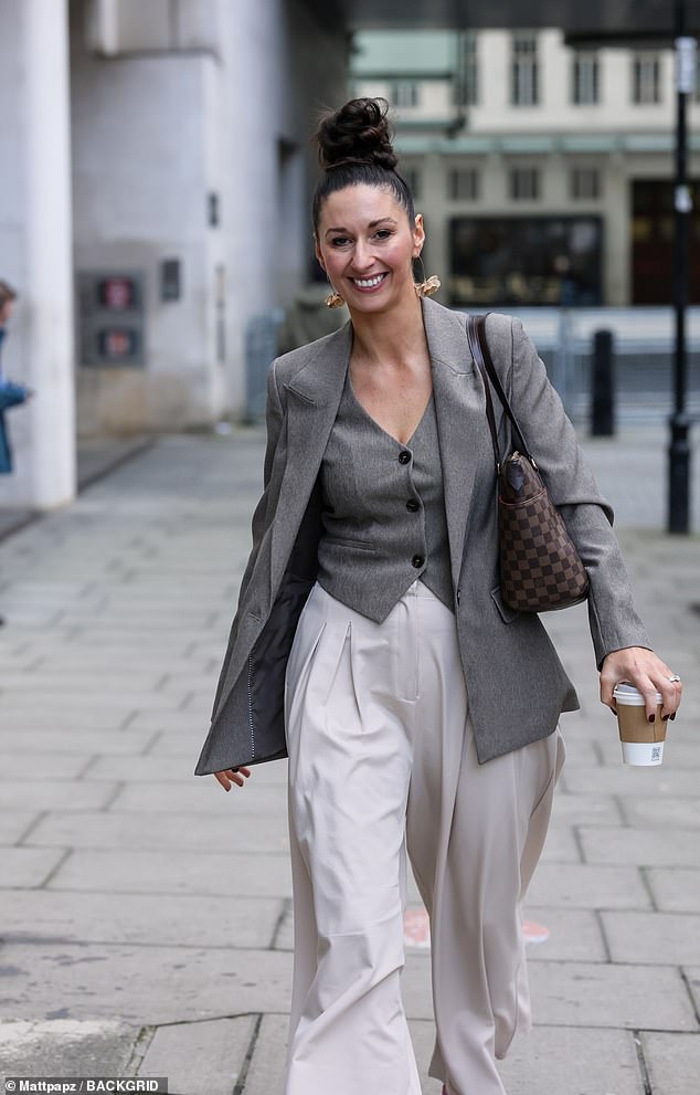 The devious Traitor cut a chic figure in a smart grey waistcoat, a matching blazer and oversized cream trousers