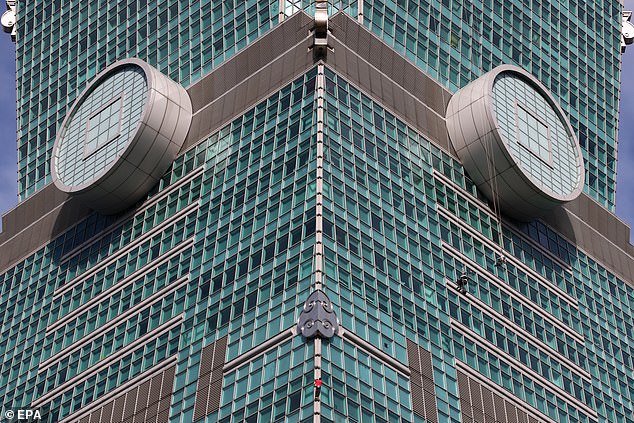 Honnold (pictured in red at the bottom of the picture) is climbing Taiwan's 1,667ft skyscraper
