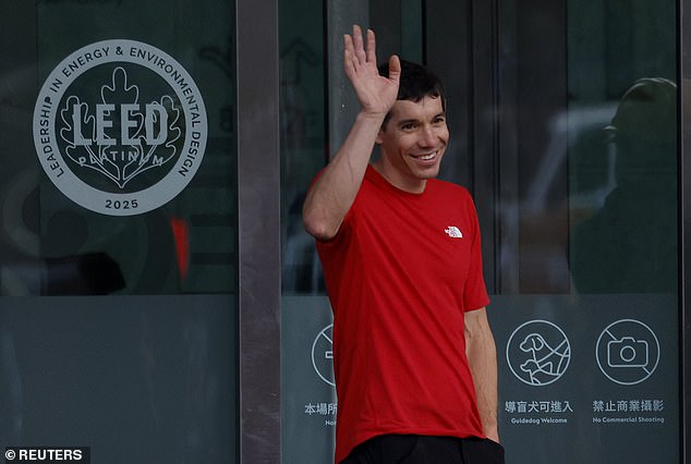 Honnold waves to the thousands of fans who lined the streets around the building to watch