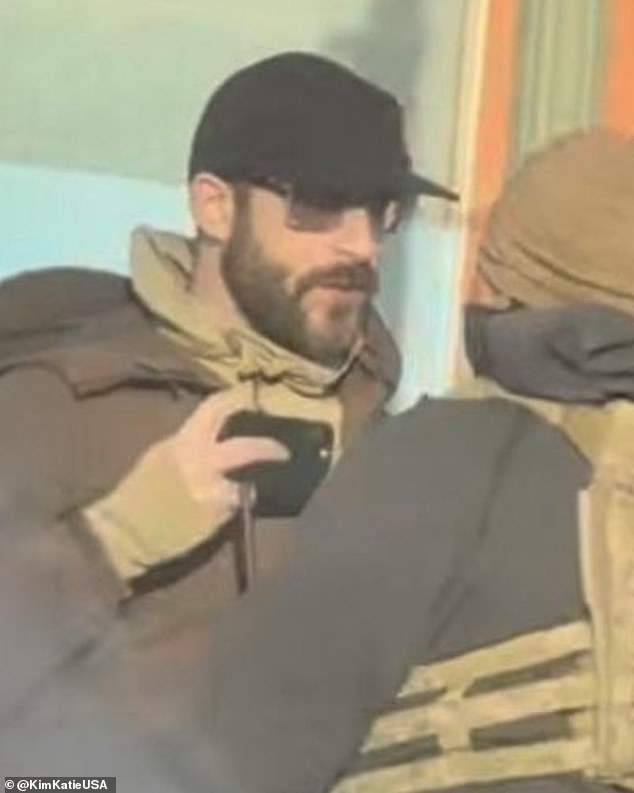 Pretti (pictured holding his phone in the face of a federal agent) was not seen in videos brandishing a weapon, despite Homeland Security Secretary Kristi Noem's claims