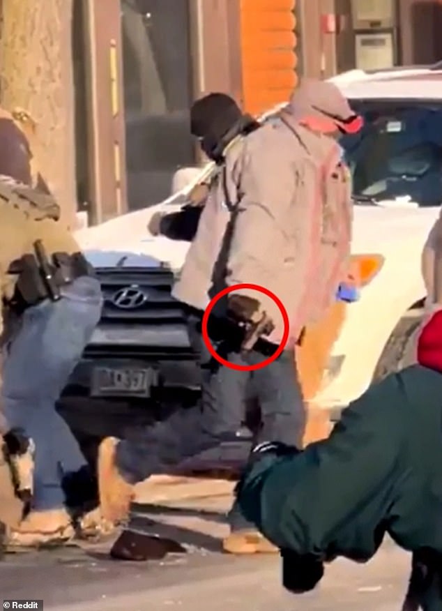 The law enforcement officer retrieves what appears to be a gun from Pretti before running across the road - at which point it may have accidentally gone off