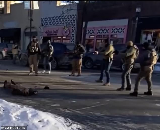 The agents can then be seen retreating into the road where at least another nine shots are fired