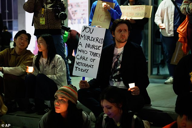 A demonstrator holds a sign during the candlelight vigil on Saturday evening