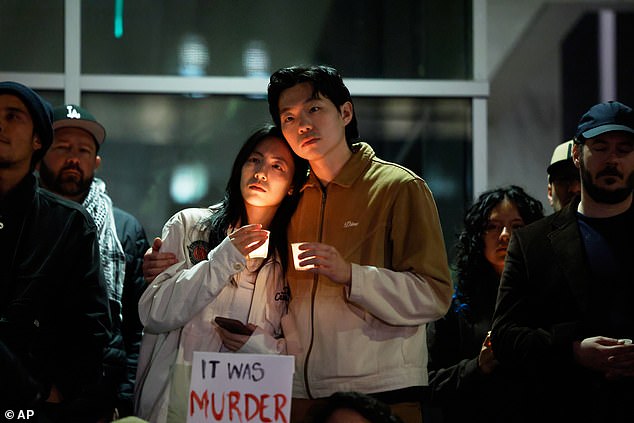 A couple embrace during a candlelight vigil