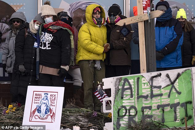 People mourn at a makeshift memorial in the area where Pretti was shot