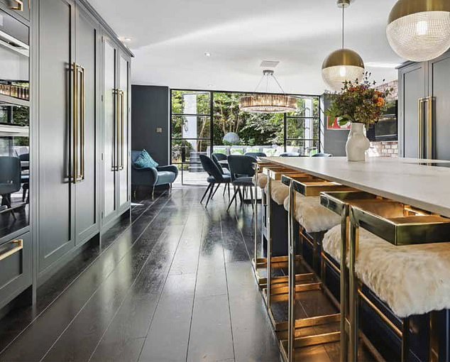 Her gorgeous kitchen boasts a sleek white breakfast bar which seats at least four people on modern golden stools complete with white cushions