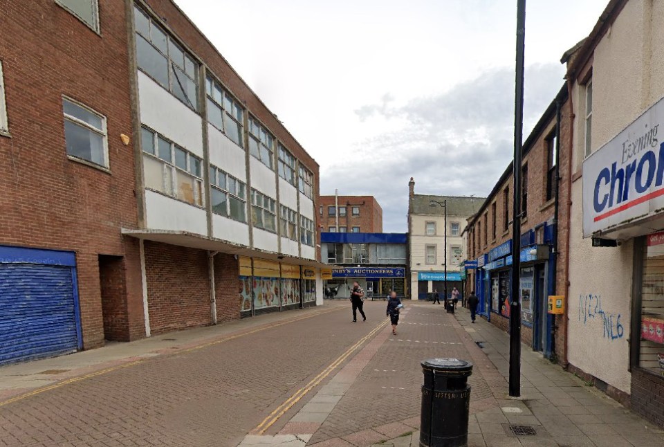 Street view of Russell Street in North Shields, with brick buildings and shops on both sides.