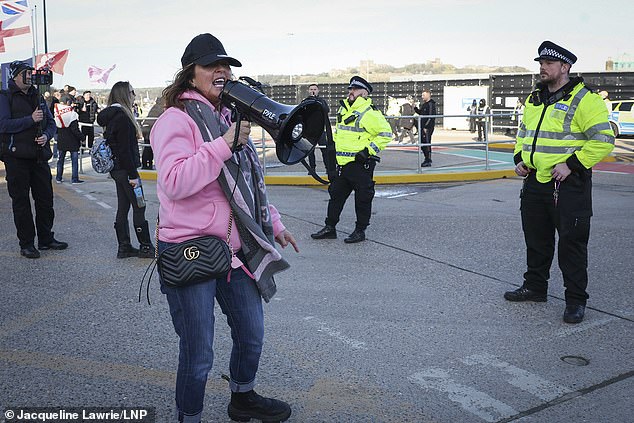 A woman uses a megaphone as anti-immigration protesters take part a demonstration named Operation Overlord at Dover Docks, in Dover on the Kent coast on January 24