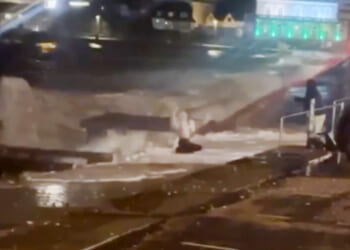 Moment woman is hit by crushing waves and nearly swept into sea while taking selfie during Storm Ingrid's fierce winds