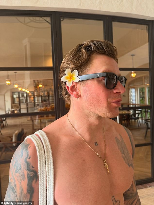 In another picture, shirtless swimmer Adam tucked a pretty flower behind his ear while exploring the resort