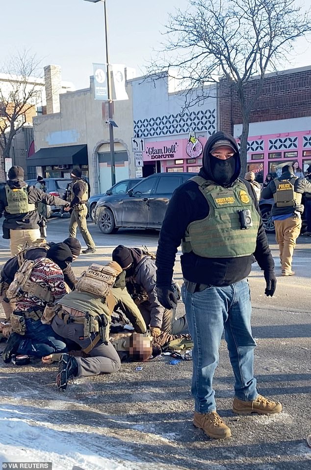 Officers are seen kneeling next to Pretti after being shot moments earlier