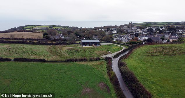 Aerial photos show the huge new barn conversion set against the tiny Cornish village